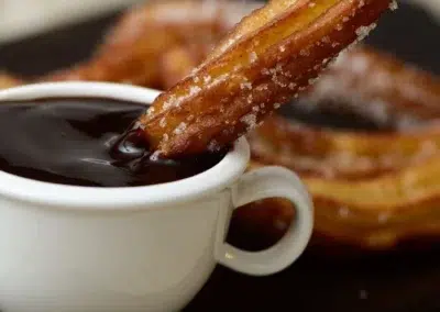 Churros trempés dans du chocolat chaud.